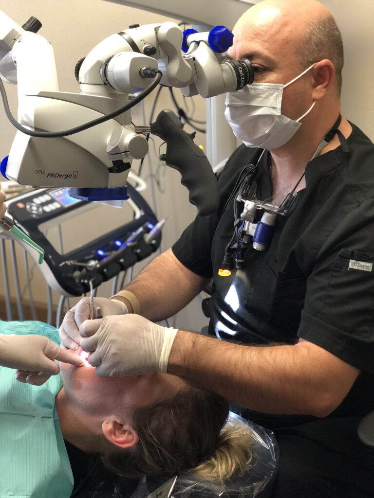 Pediatric dentist performing a precise dental procedure for a young patient using advanced technology at Mona Lisa Smile Dental in Walnut Creek, CA